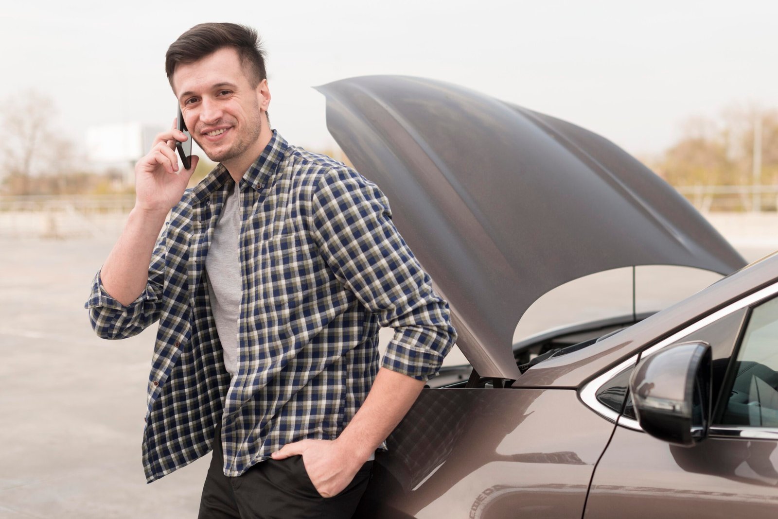 man-with-broken-car-talking-phone